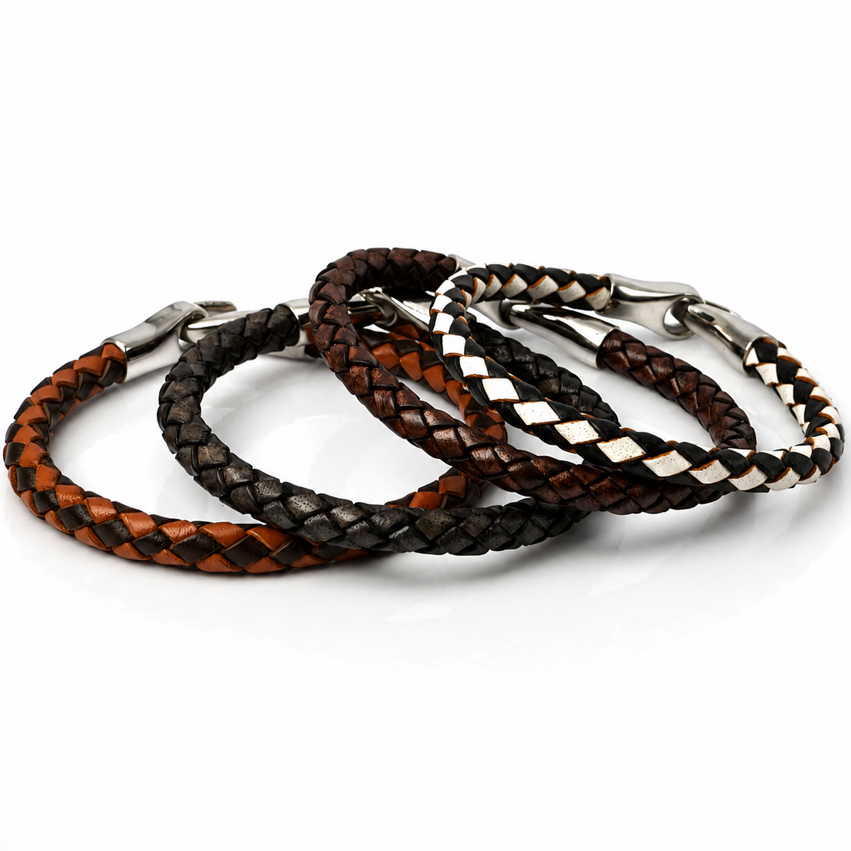 Four braided leather bracelets in brown, black, and white tones with silver-tone metal clasps, arranged on a white background.