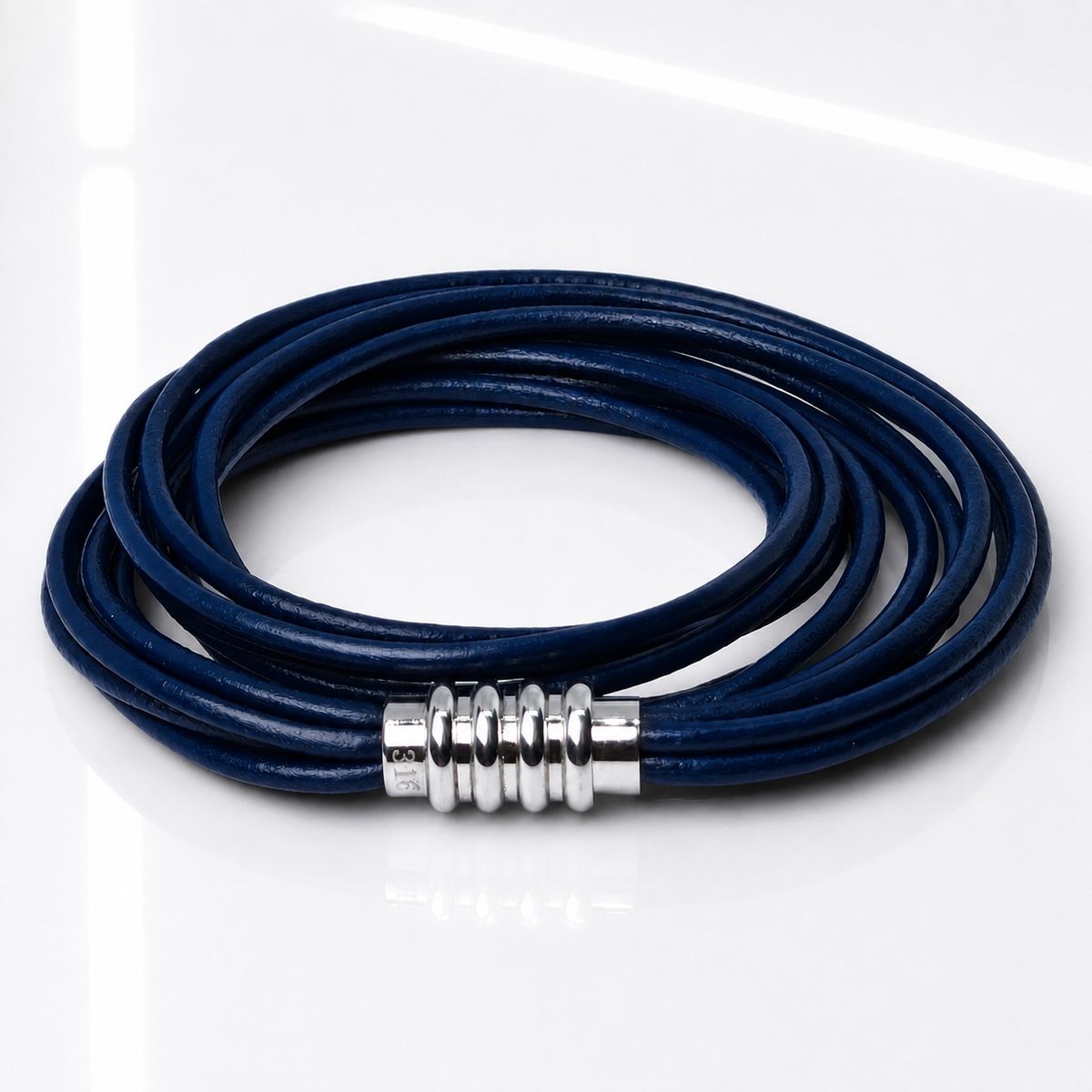 A multi-strand navy blue leather cord bracelet with a textured silver metal clasp, displayed on a clean white reflective surface.
