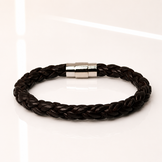 A dark brown braided leather bracelet with a polished silver magnetic clasp, displayed on a clean white reflective surface.