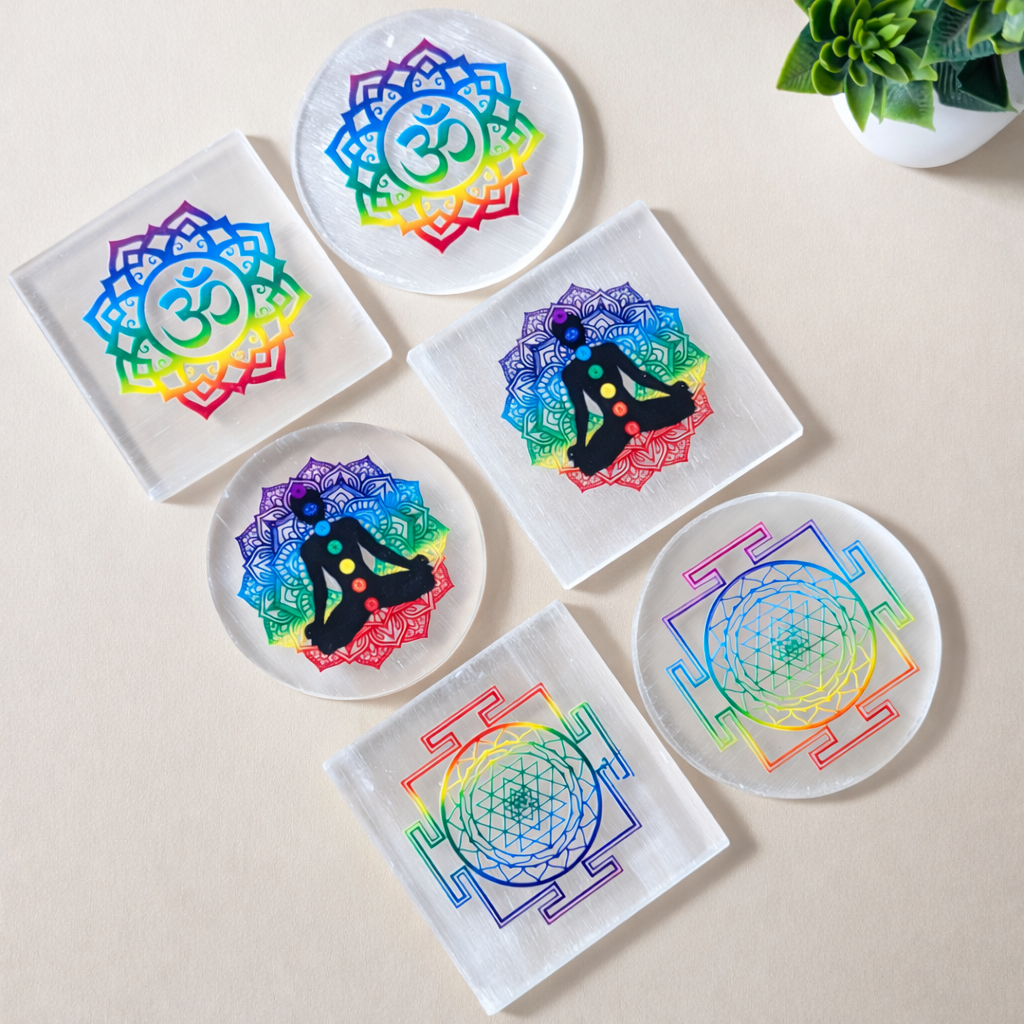 Set of whiteSelenite plates with colorful mandala designs on a beige surface.