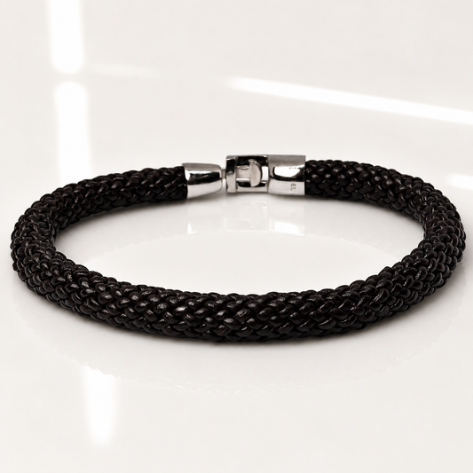 A black braided cord bracelet with a polished silver-toned clasp, displayed on a clean white reflective surface.