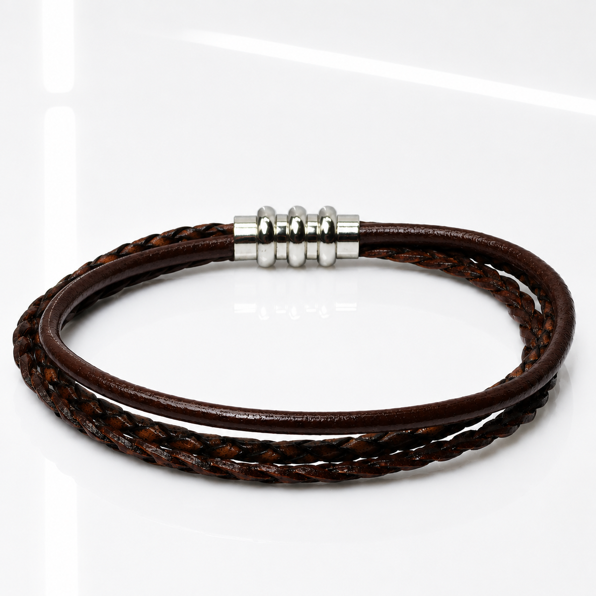 A multi-strand brown leather bracelet with a silver-toned metal bead clasp, displayed on a clean white reflective surface.