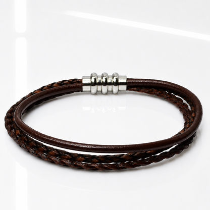 A multi-strand brown leather bracelet with a silver-toned metal bead clasp, displayed on a clean white reflective surface.