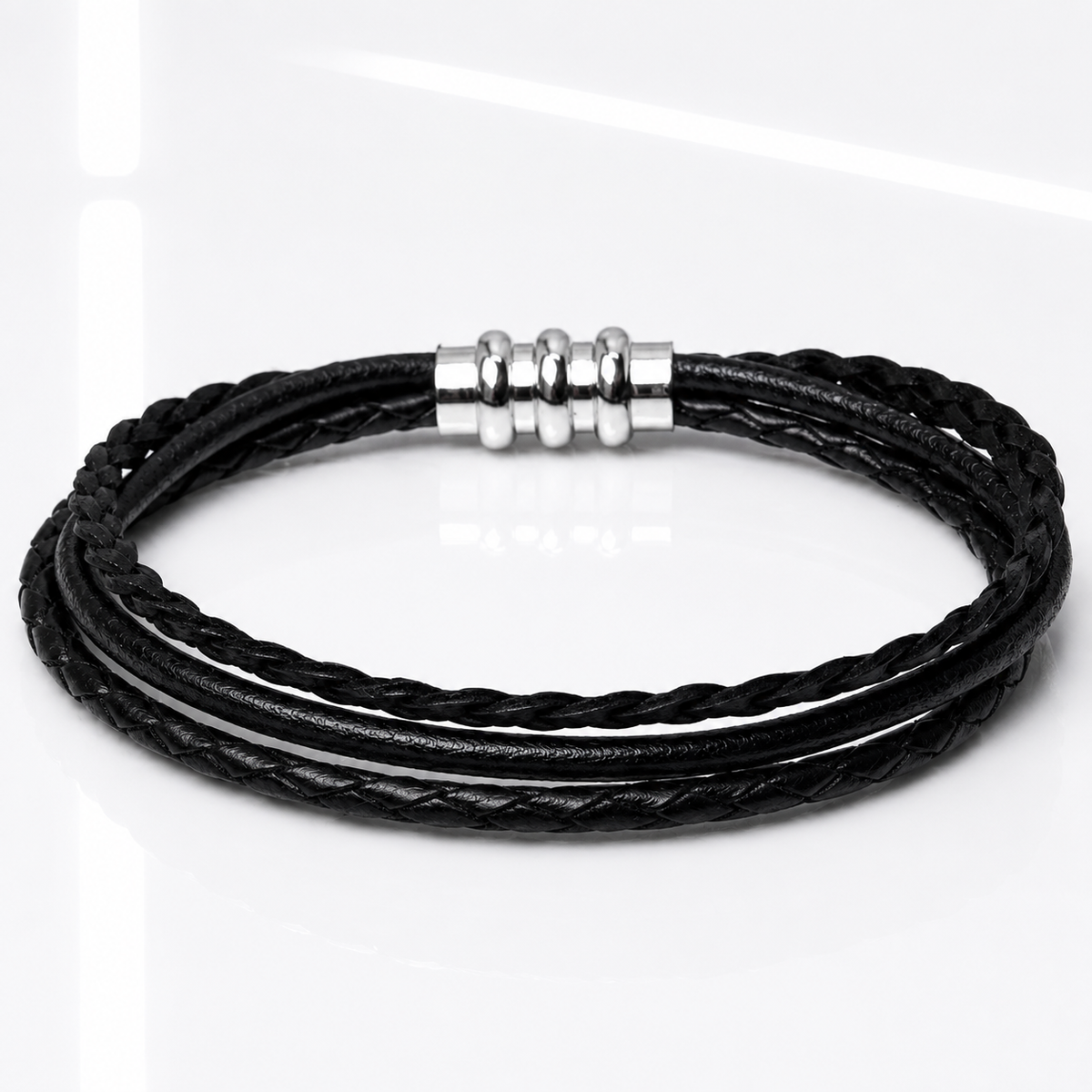 A black multi-strand braided leather bracelet with a polished silver-toned metal clasp, displayed on a clean white reflective surface.