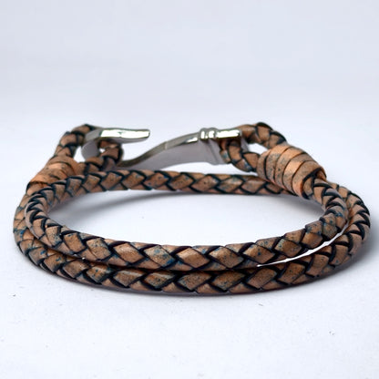 A braided leather bracelet with a silver-toned metal clasp, shown on a plain light gray background.