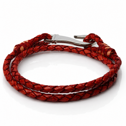 A red braided leather wrap bracelet with a silver metal lobster clasp, coiled on a white background.