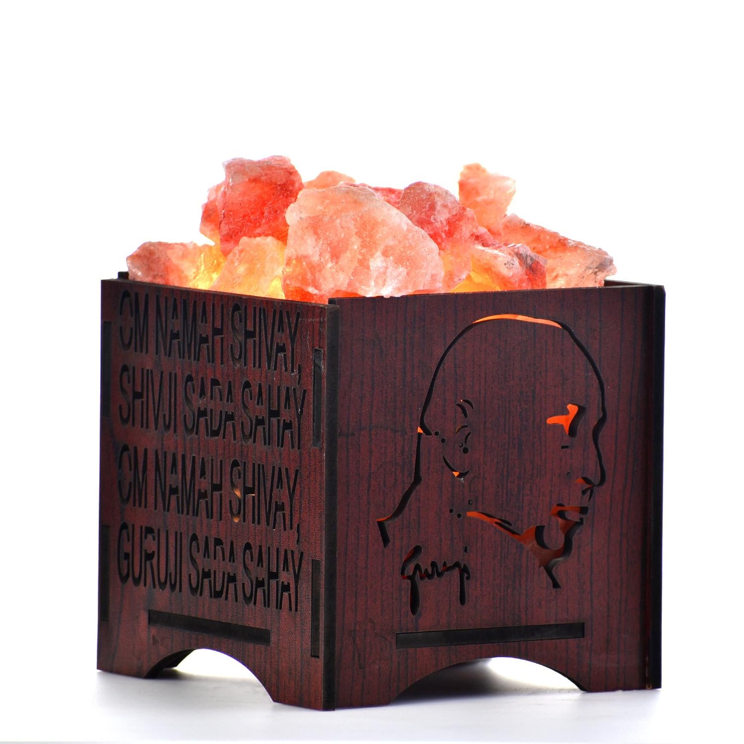 Himalayan salt lamp with wooden base featuring engravings on a white background