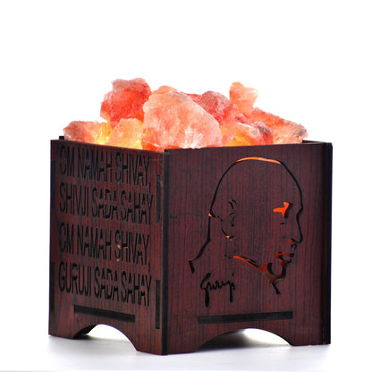 Himalayan salt lamp with wooden base featuring engravings on a white background
